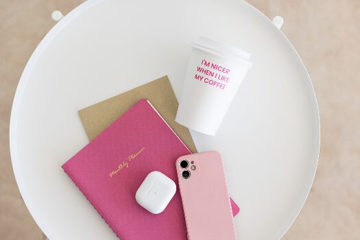 white table with pink books and cell phone
