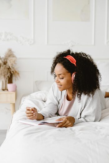 Girl laying on bed wearing red headphones