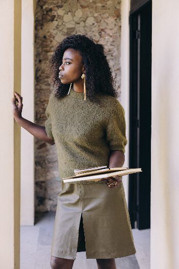 Woman in green sweater holding books